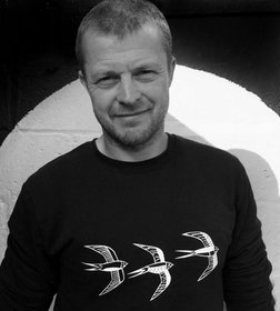 photo of david parker, wearing a black sweatshirt with yellow birds on the front.